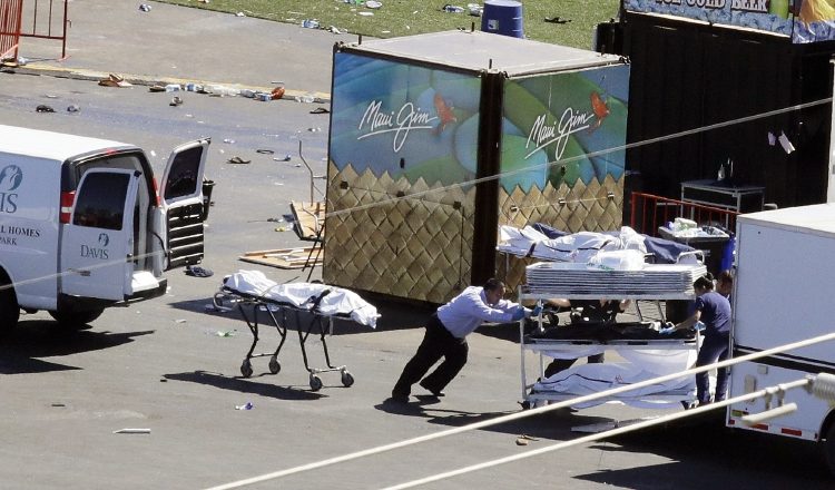 Los investigadores cargan un camión al lado de un cuerpo de la escena del tiroteo en masa. /Foto AP
