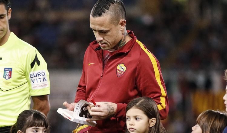 Radja Nainggolan, de Roma, entrega a una niña una copia del Diario de Ana Frank. /Foto EFE