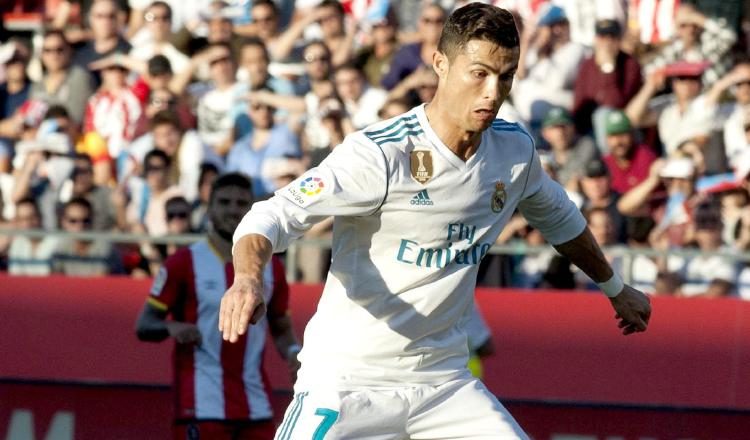 Cristiano (izq.) disputa un balón contra Marc Muniesa, del Girona. /Foto EFE