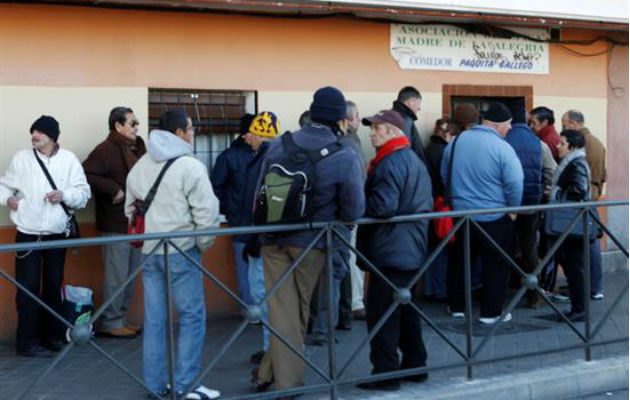 Un grupo de personas guarda cola para entrar en un comedor social, en Madrid. Foto: EFE