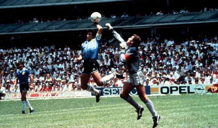Momento en que Diego Armando Maradona (izq.) anota el gol llamado "la mano de Dios", para abrir el marcador sobre Inglaterra.