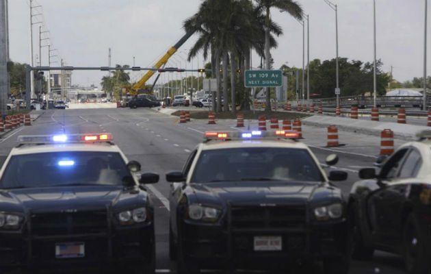 Los patrulleros de la autopista de Florida bloquean la carretera cerca de donde se derrumbó el puente peatonal de FIU. FOTO/AP