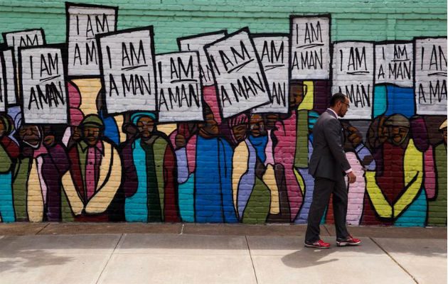 Varias personas caminan frente a una pared pintada cerca del Motel Lorraine, donde fue asesinado Martin Luther King. Foto: EFE