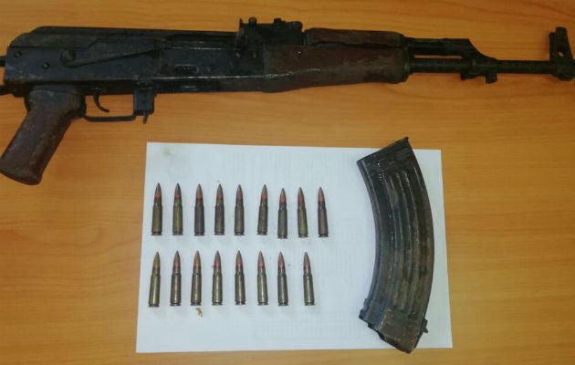 El arma encontrada, junto a varias municiones.