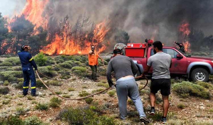 Varios bomberos y voluntarios luchan contra las llamas en un incendio en Verori, cerca de la ciudad de Loutraki (Grecia). EFE