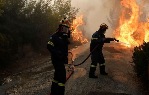 Bomberos tratan de extinguir un incendio en Penteli. Foto: EFE