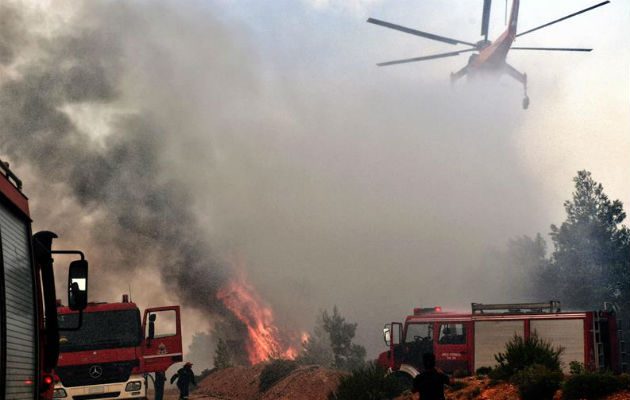 Un helicóptero intenta extinguir un fuego en Verori. Foto: EFE 