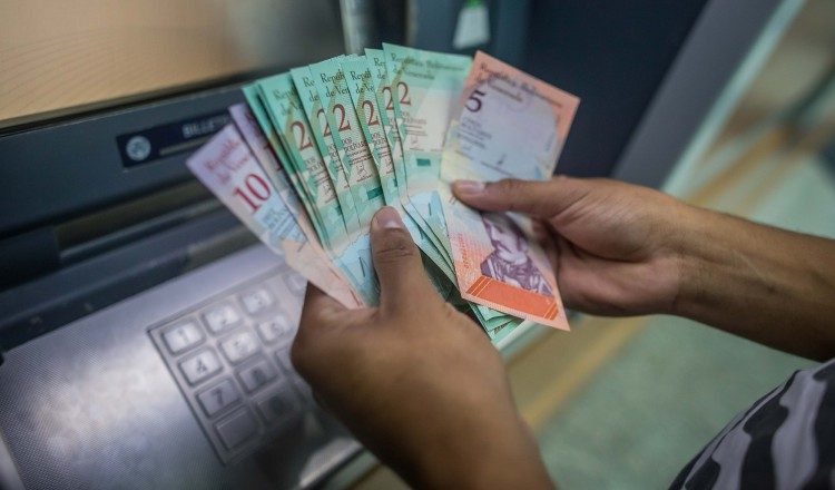 Una persona cuenta dinero del nuevo cono monetario retirado de un cajero. /Foto EFE