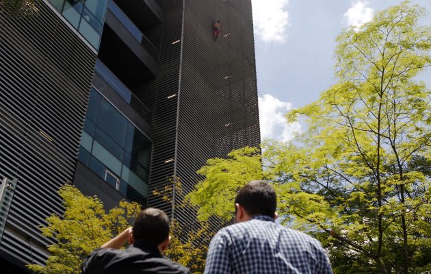 El escalador ruso Pavel Gogulan (i), conocido internacionalmente como el "Spiderman ruso", escala, si ningún tipo de protección, un edificio en Medellín. FOTO/EFE