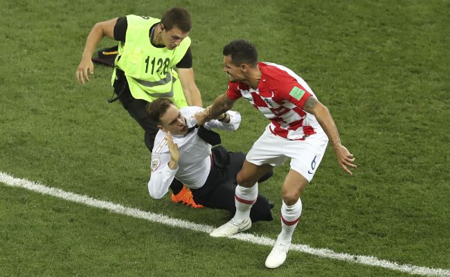 Pyotr Verzilov (cent.) en la final del mundial de Rusia es atrapado por un seguridad. Foto:AP