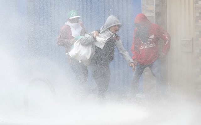  Tres personas llevan bolsas con elementos luego de ingresar a un local comercial saqueado durante las protestas, en un sector de Patio Bonito, sur de Bogotá. FOTO/EFE