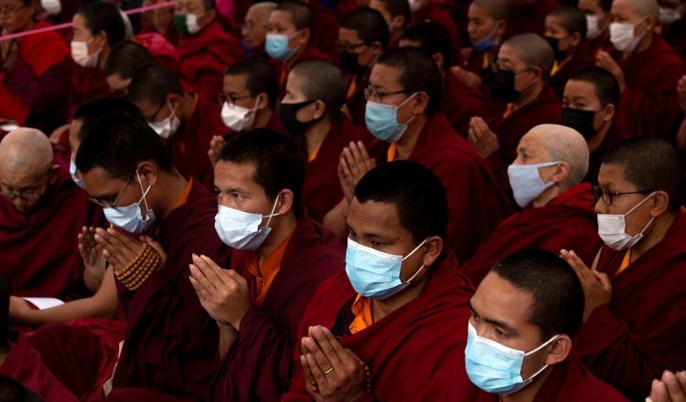 En Katmandú (Nepal), monjes budistas oran con máscaras protectoras.  EFE
