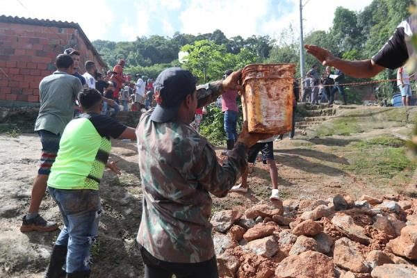 habitantes y bomberos buscando a los desaparecidos tras el derrumbe en el "Morro do Macaco Molhado", en Guarujá (Brasil). FOTO/EFE