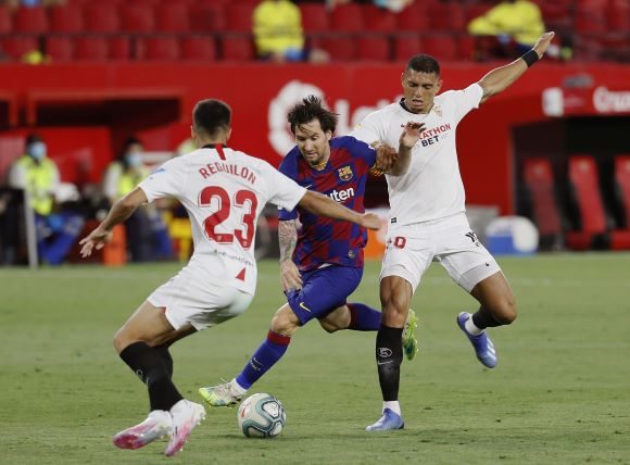 Los defensas del Sevilla, Diego Carlos (der,) y Reguilón (izq.) disputan un balón ante e Leo Messi del Barcelona. Foto:EFE