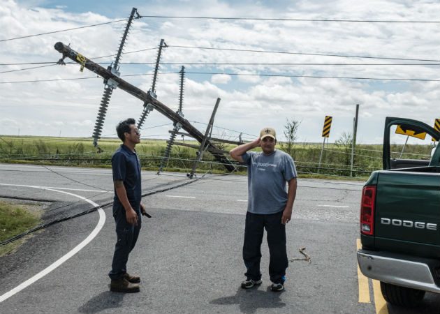 Dos hombres detienen sus autos ante la caída de un poste en la autopista en Iowa, Louisiana (EE.UU). Fotos: EFE.