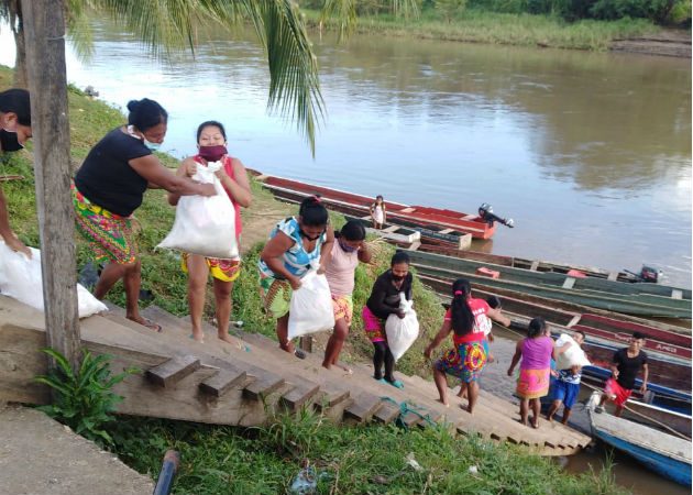 Las Werârâ (mujeres) de Unión Chocó descargando las bolsas de la piragua. Fotos: Cortesía.