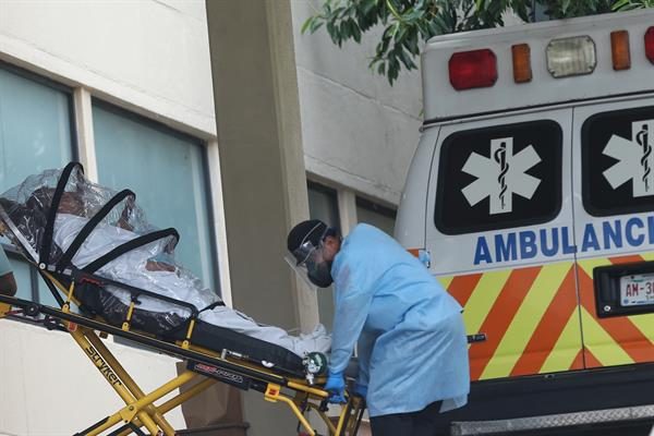 Personal de salud traslada a una persona contagiada con la covid-19 en la zona de emergencias del Hospital General , en la Ciudad de México. EFE