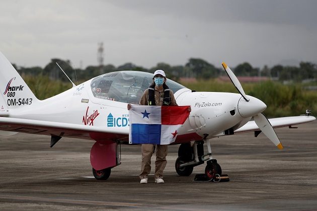 Zara Rutherford posa con la bandera de Panamá tras aterrizar en su avión "Shark" en una pista del área de carga del Aeropuerto Internacional de Tocumen. Foto: EFE