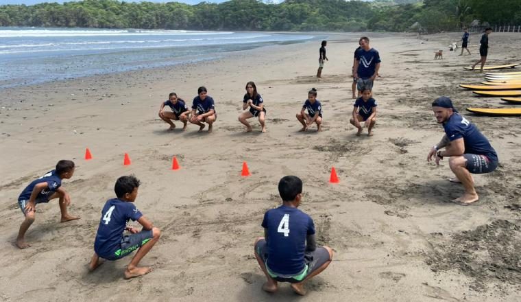 Nils Lleonart, coordinador de surf dando algunas instrucciones a los estudiantes en la playa.