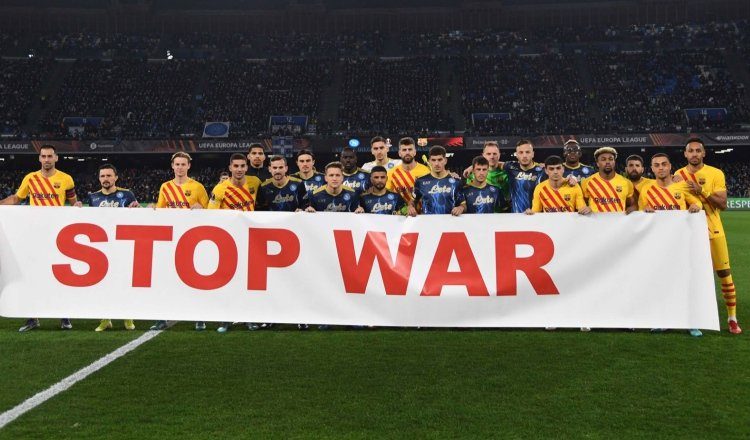 Jugadores del Nápoles y Barcelona sostienen una pancarta que dice "alto a la guerra" antes del partido de vuelta de la eliminatoria de la Liga Europa. Foto:EFE