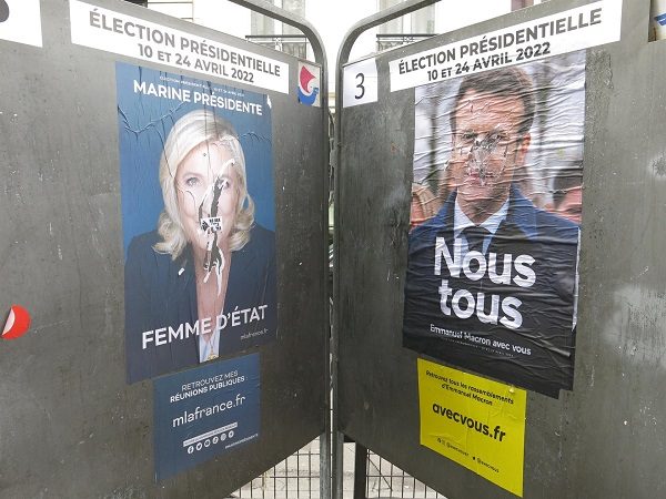 Dos carteles electorales de Emmanuel Macron y Marine Le Pen se "enfrentan" también en las calles de París. EFE/Rafael Cañas