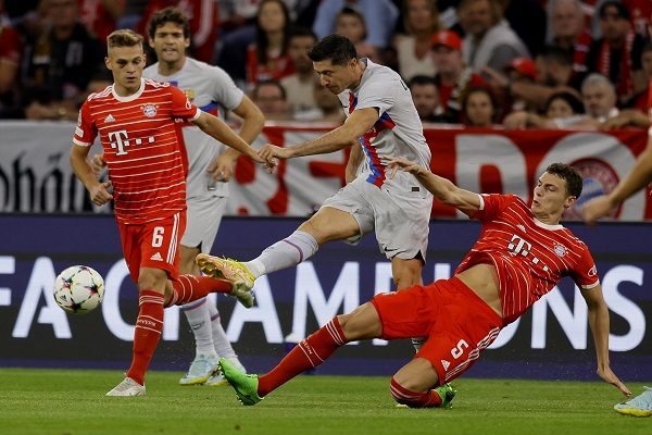 Robert Lewandowski del Barcelona (cent.) patea el balón ante la marca de Benjamin Pavard (der) y Joshua Kimmich (izq.) en a Champions. Foto:EFE