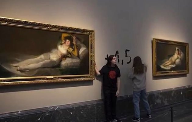 Activistas de la organización Futuro Vegetal se pegan a los marcos de los cuadros de "La maja vestida" y "La maja desnuda". Foto: EFE