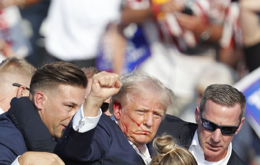 Donald Trump caminó con el puño en alto desde el escenario rodeado de los elementos del Servicio Secreto, pero las imágenes dan a entender que fue herido. Foto. EFE