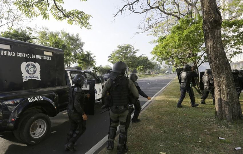 Policías antidisturbios vigilan un área durante protestas. Foto: EFE