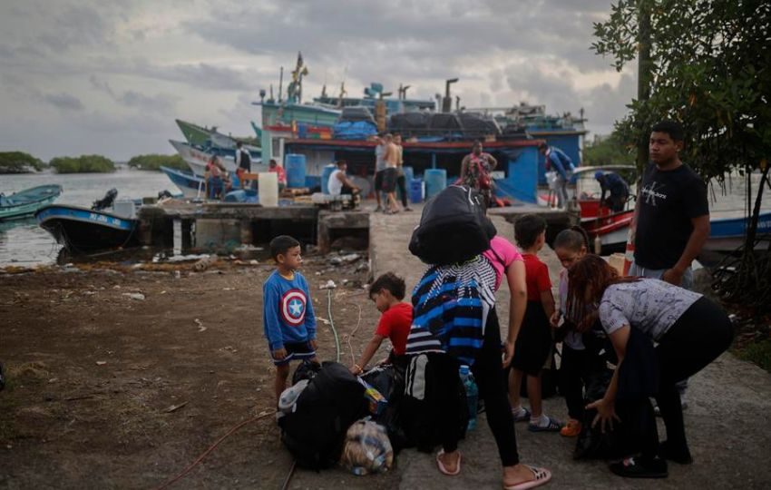 Migrantes venezolanos haciendo fila para abordar una lancha que los lleve a la frontera con Colombia. Fotos: EFE