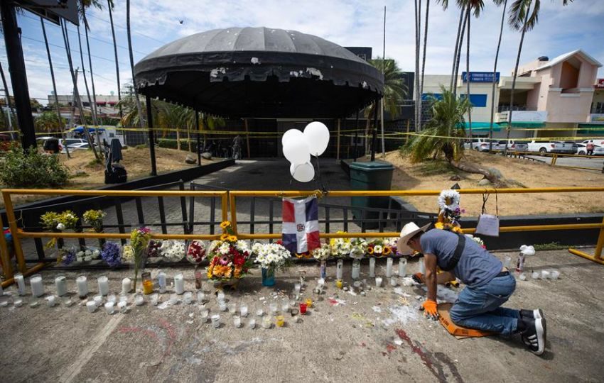 Un hombre enciende velas en la entrada de la discoteca Jet Set. Foto: EFE