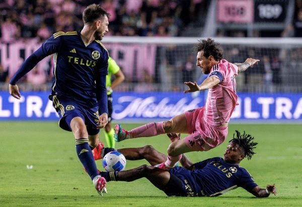  Lionel Messi es marcado por Edier Ocampo (der) y Tristan Blackmon del Vancouver Whitecaps, en la Copa de Campeones de la Concacaf. Foto: EFE