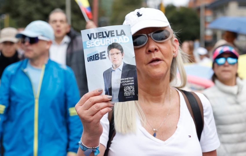 Una mujer sostiene un cartel durante una caminata por la paz y en apoyo al senador Miguel Uribe Turbay. Foto: EFE