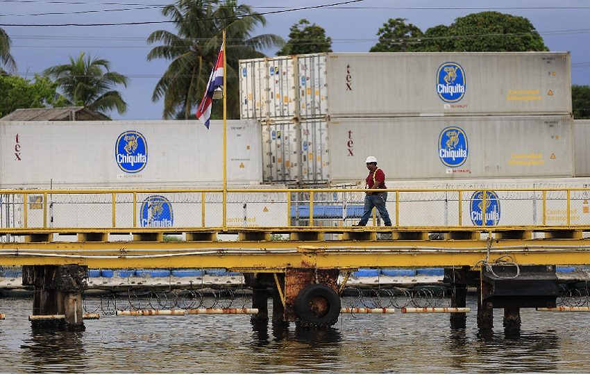 Un hombre camina frente a contenedores de la empresa bananera Chiquita este martes, en Puerto Almirante (Panamá). EFE/ Bienvenido Velasco