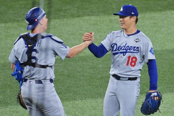 Yoshinobu Yamamoto (18)  y el recpector Will Smith festejan el triunfo de los Dodgers. Foto: EFE