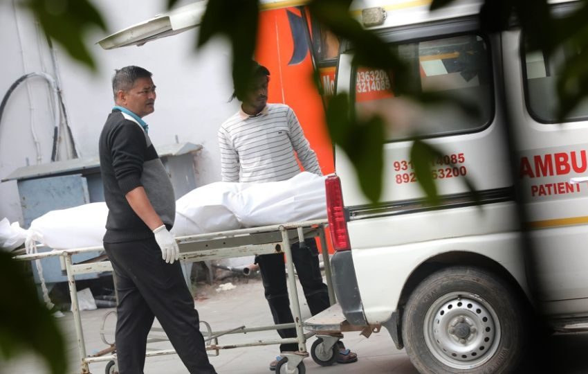 El cuerpo de una víctima es trasladado fuera de la morgue del Hospital Lok Nayak. Foto: EFE
