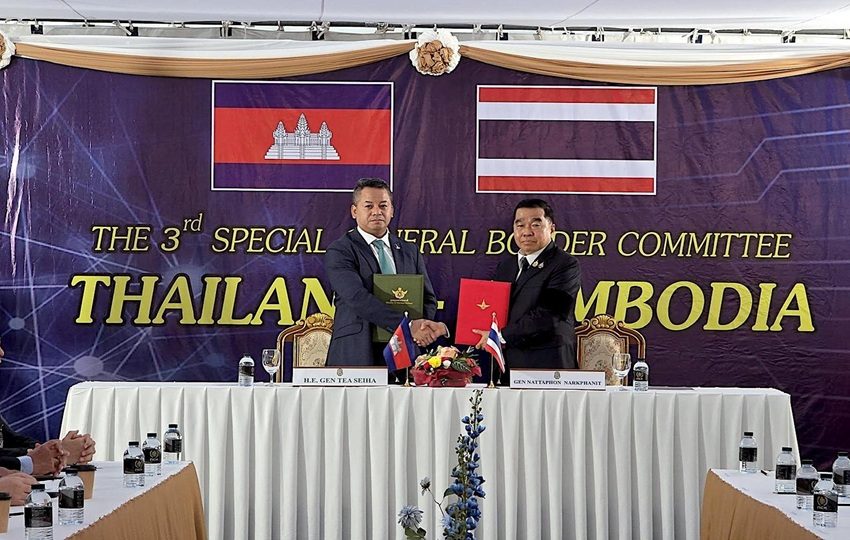 Tea Seiha (I) y Natthaphon Narkphanit (D), los ministros de Defensa de Camboya y Tailandia, respectivamente, intercambian el acuerdo firmado de cese al fuego. Foto: EFE