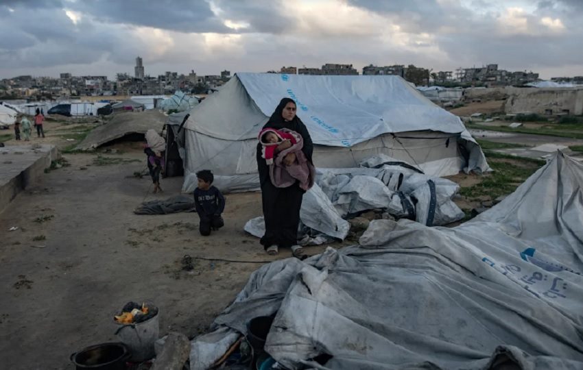 Una familia palestina intenta recoger lo que queda de sus pertenencias después de que su tienda de campaña fuera dañada por los fuertes vientos. Foto: EFE