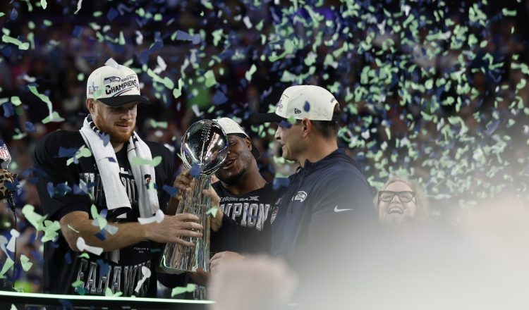 El entrenador en jefe de los Seattle Seahawks, Mike Macdonald (der.), entrega el Trofeo Lombardi al mariscal de campo, Sam Darnold. Foto: EFE