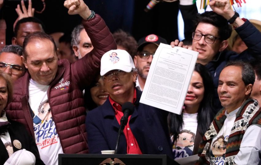 El presidente de Colombia, Gustavo Petro, sostiene el nuevo decreto del salario. Foto: EFE