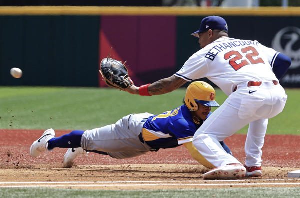 Gustavo Campero (izq.) de Colombia se lanza a primera base ante Christian Bethancourt de Panamá . Foto: EFE