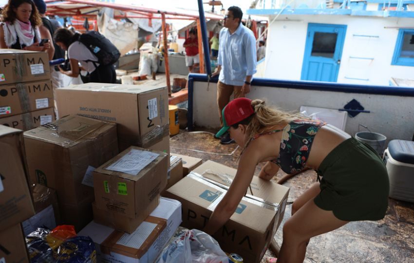 Activistas suben ayuda humanitaria a un buque con destino a Cuba. Foto: EFE