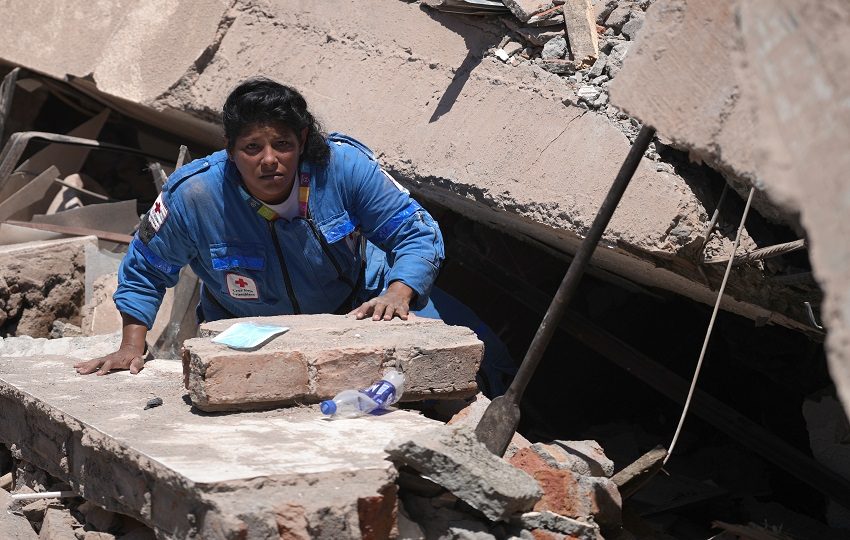 Una integrante de la Cruz Roja de Colombia busca entre los escombros de una edificación colapsada. Foto: EFE