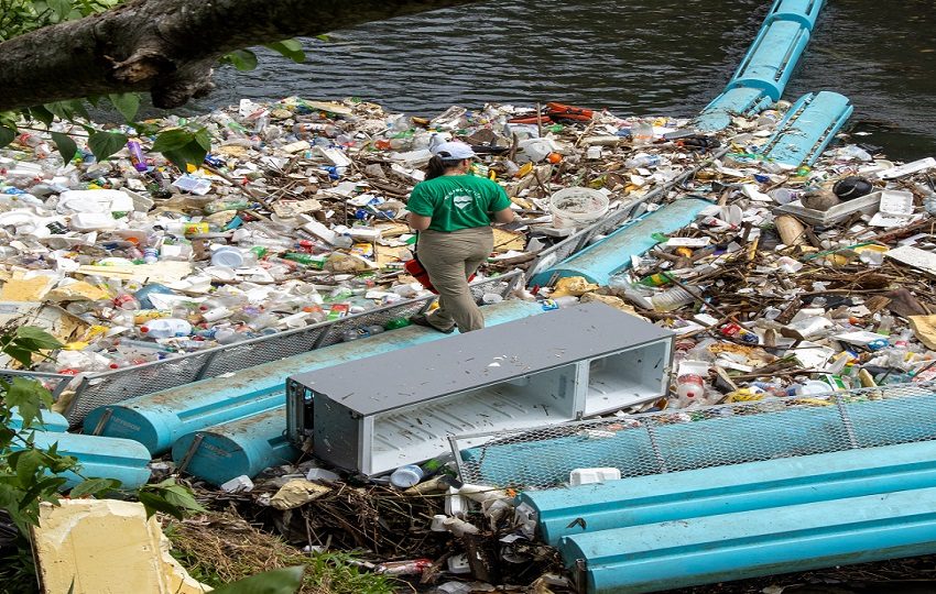 Cuatro personas trabajan en la recolección y clasificación de los desechos que recoge la barrera en el río Matías Hernández. Foto: Cortesía