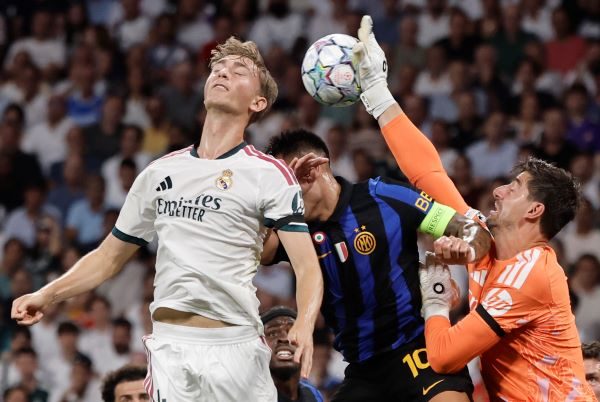 El guardameta del Real Madrid Thibaut Courtois (der.) despeja el balón ante la llegada del argentino Lautaro Martínez, del Inter. Foto: EFE