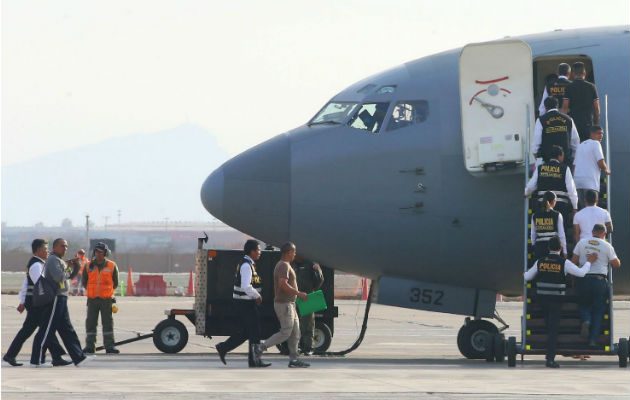 Policías escoltan a venezolanos en una base militar del Callao, donde fueron deportados por dar información personal falsa. Foto: AP.