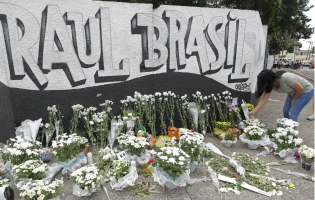 Una mujer coloca flores como tributo a las víctimas de la matanza en Suzano, Brasil. Foto: AP.