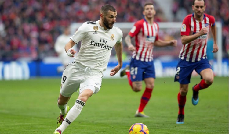 El delantero francés del Real Madrid Karim Benzema (Izq.) controla el balón ante rivales del Atlético de Madrid. Foto:EFE