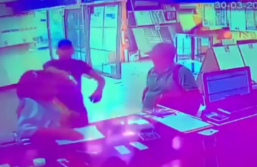 Uno de los delincuentes saca un arma de fuego y apunta directamente a la persona que administraba el local comercial.