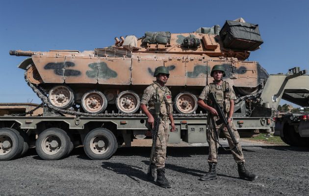 Jóvenes con la bandera turca al paso de blindados militares turcos en el noreste de Siria. Foto: EFE.